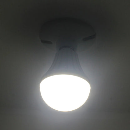 Bombilla LED tipo bulbo encendida con luz blanca brillante, vista desde abajo en un techo oscuro