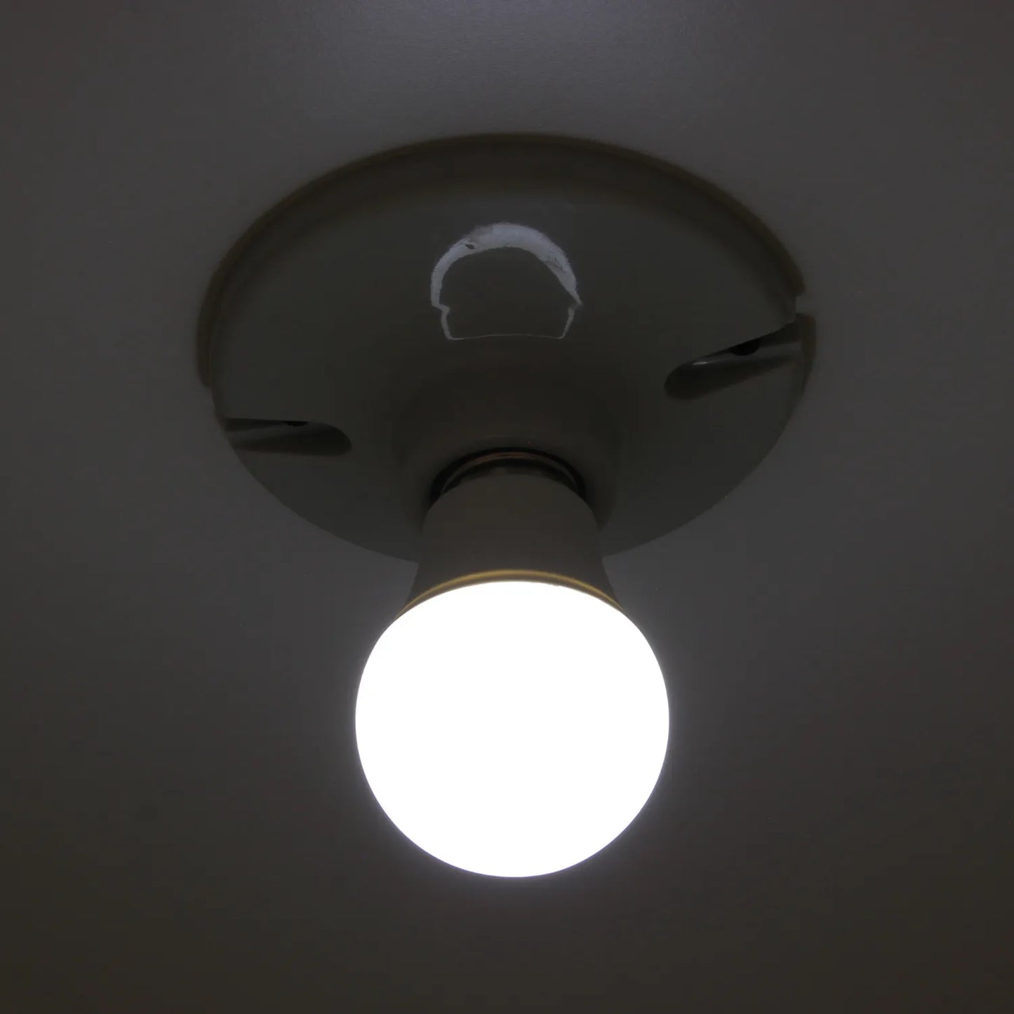 Foco LED de luz blanca fría, brillando intensamente desde un portalámparas de techo. Iluminación eficiente.
