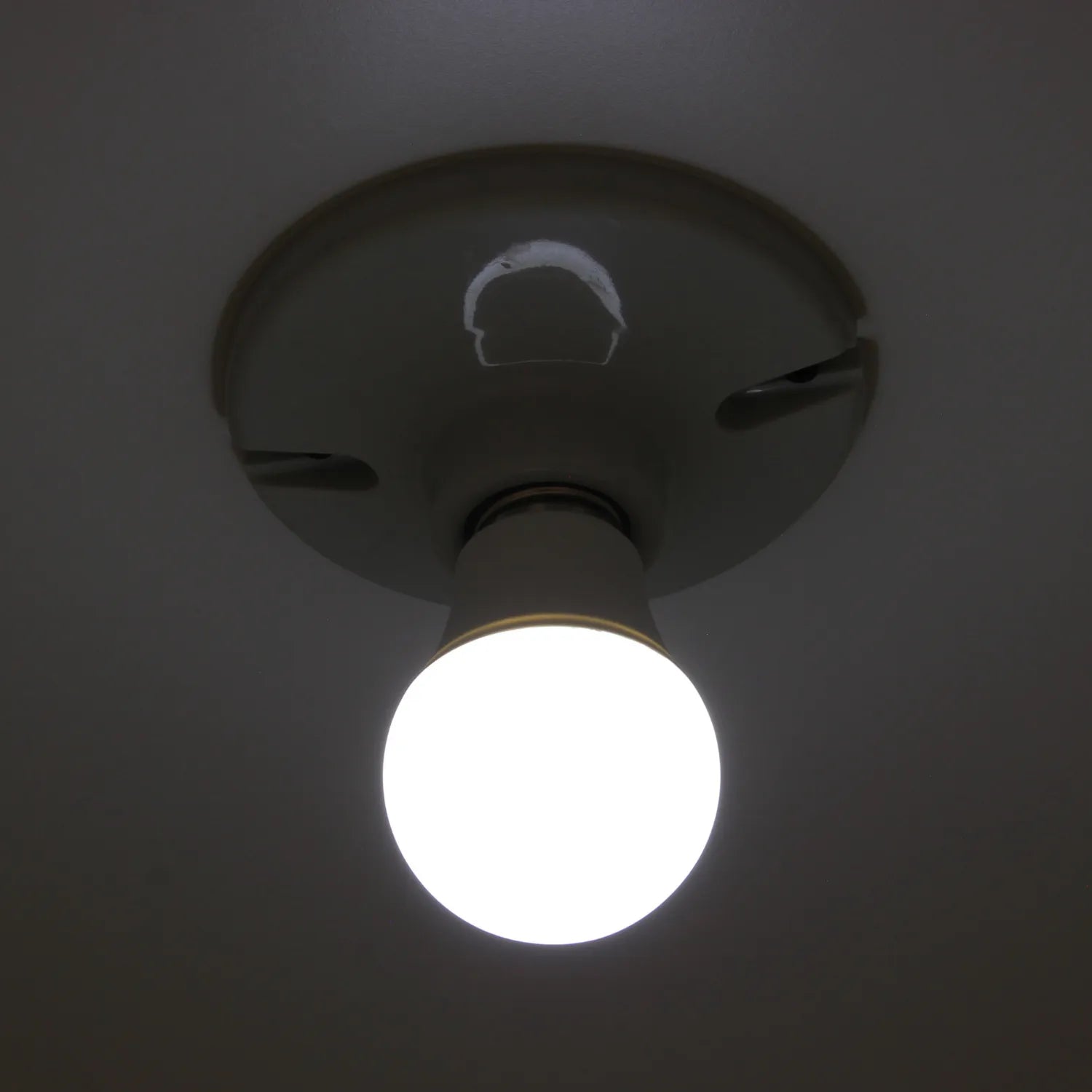 Foco LED de luz blanca fría, brillando intensamente desde un portalámparas de techo. Iluminación eficiente.