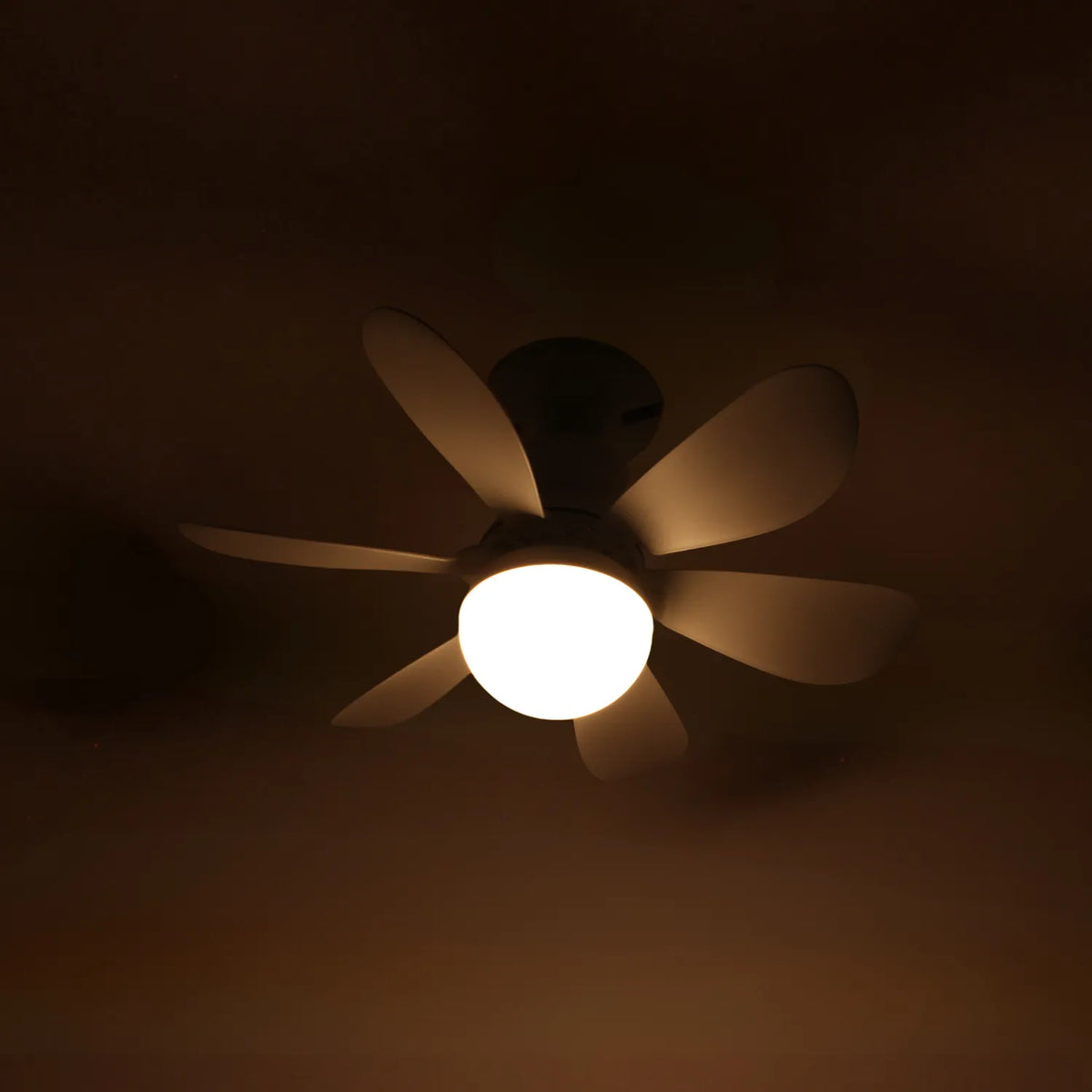 Ventilador de techo moderno de 6 aspas blancas con luz LED central redonda encendida para interiores.