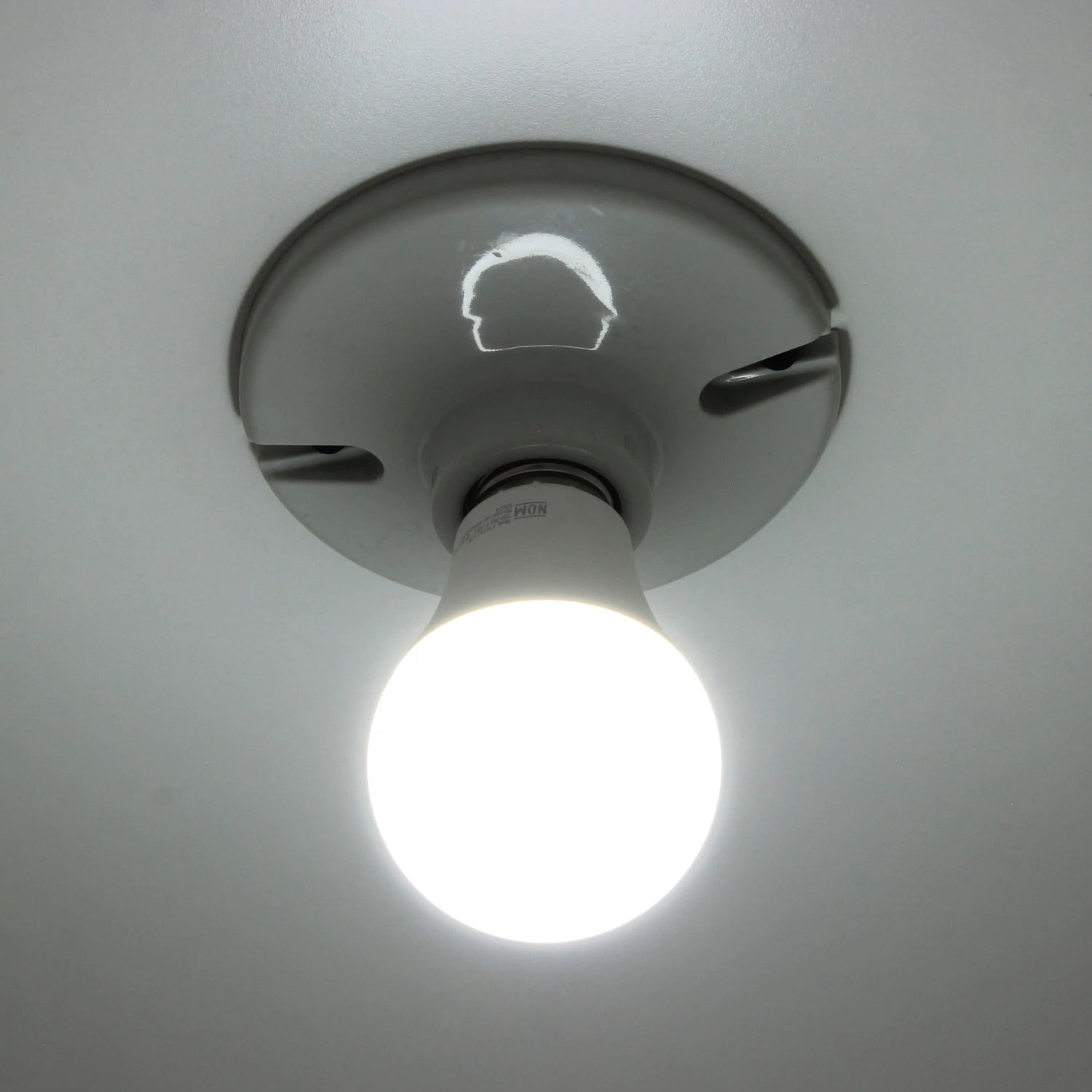 Foco LED de luz blanca fría encendido, montado en plafón de techo gris claro